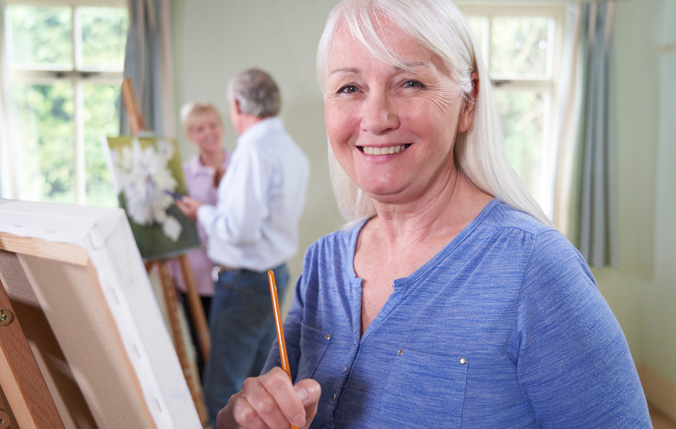 Woman smiling while in a painting class