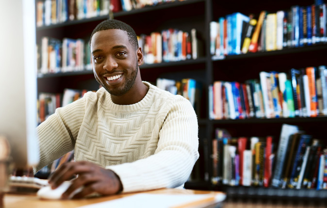 Man smiling while using a computer